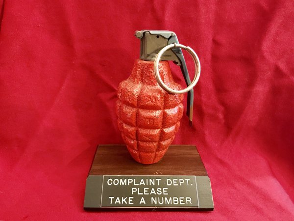 Thrift shop find of Complaint Dept, please take a number and it is a grenade with pin for number.