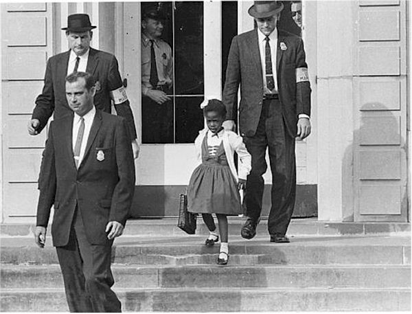 Ruby Bridges, the little black girl who desegregated new Orleans schools, is only 62.

In early 1960, Bridges was one of six black children in New Orleans to pass the test that determined whether they could go to the all-white school, William Frantz Elementary. Bridges was the only one who decided to go to the new school. She and her mother were escorted to school by four federal marshals during the first year Bridges attended William Frantz Elementary.
As soon as Bridges entered the school, white parents pulled their own children out; all the teachers refused to teach while a black child was enrolled. Only one person agreed to teach Ruby and that was Barbara Henry, from Boston, Massachusetts, and for over a year Henry taught her alone, “as if she were teaching a whole class.”
On the second day a white student broke the boycott and entered the school when a 34-year-old Methodist minister, Lloyd Anderson Foreman, walked his 5-year-old daughter Pam through the angry mob, saying, “I simply want the privilege of taking my child to school …” A few days later, other white parents began bringing their children, and the protests began to subside.
The Bridges family suffered for their decision to send her to William Frantz Elementary: her father lost his job, the grocery store the family shopped at would no longer let them shop there, and her grandparents, who were sharecroppers in Mississippi, were turned off their land. She has noted that many others in the community, both black and white, showed support in a variety of ways. Some white families continued to send their children to Frantz despite the protests, a neighbor provided her father with a new job, and local people babysat, watched the house as protectors, and walked behind the federal marshals’ car on the trips to school.
