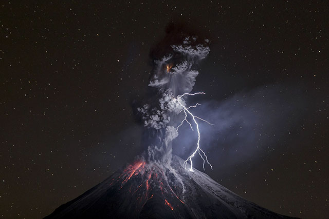 This photo just won national geographic travel photograph of the year. Photo by Sergio Tapiro.

A lightning bolt pierces the night sky over Mount Colima as a column of swirling ash erases the stars in its path.