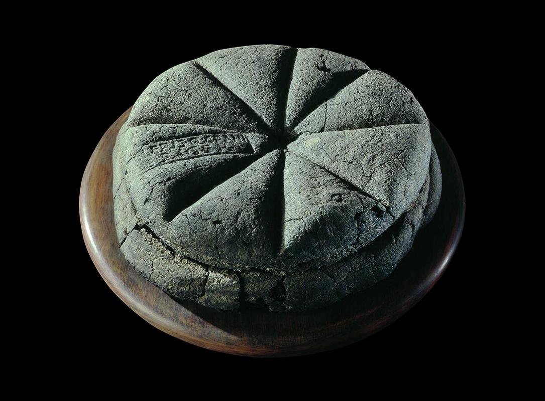 A carbonised loaf of bread with the stamp ‘Property of Celer, Slave of Q. Granius Verus’, Herculaneum (near Pompeii), 79 AD.
