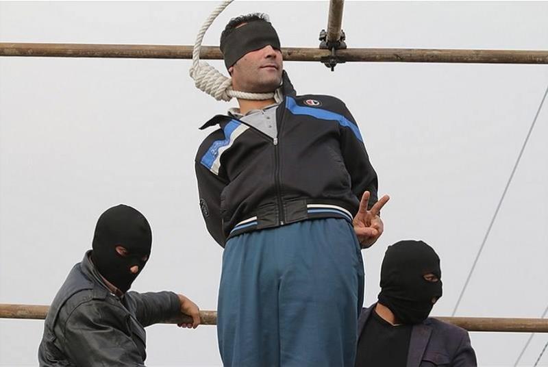 Iranian man gives the peace sign before execution.

Hanged in public in November 2014, 36-year-old Nader Haghighat Naseri had one message to those observing the execution in Mashhad, Iran: peace and victory.
Naseri was a member of an armed group which engaged in several episodes of armed robbery, and was convicted of Moharebeh, or waging war against God.