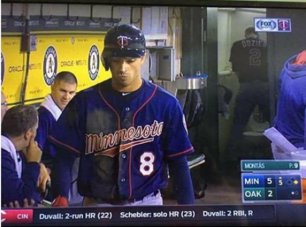 Video from the dugout of a baseball game and someone forgot to close the door to the bathroom in the background.