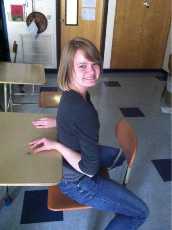 double jointed girl sitting backwards at a table with her arms in the correct position