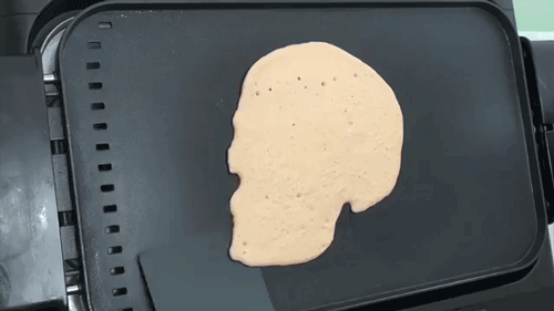 GIF of flipping a pancake of an elaborate skull