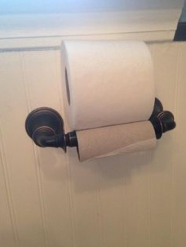 First world frustrations of toilet paper roll lazily placed atop the empty roll.