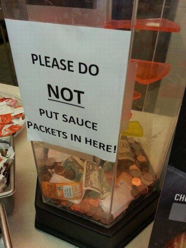 Tips jar with sign requesting people stop putting sauce packets in there.