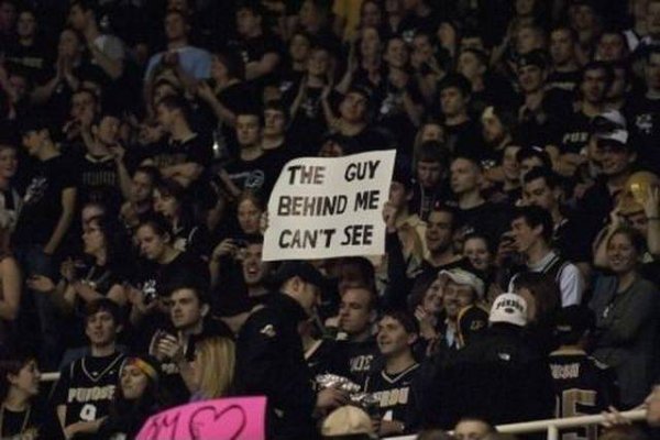 Guy holding massive sign at a game that says THE GUY BEHIND ME CAN'T SEE