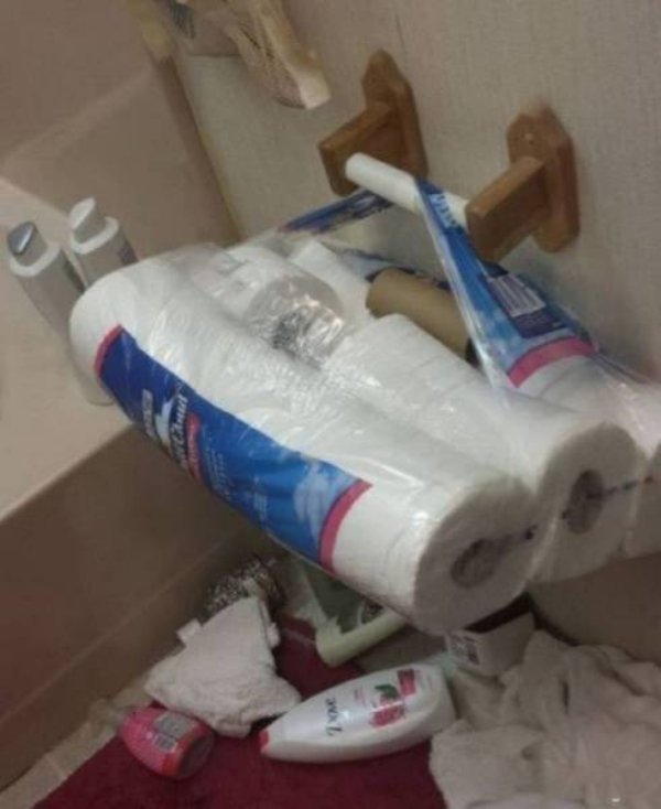 Toilet paper roll holder holding pack of TP