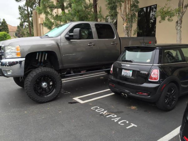 Massive pick up truck parked in compact car spot.