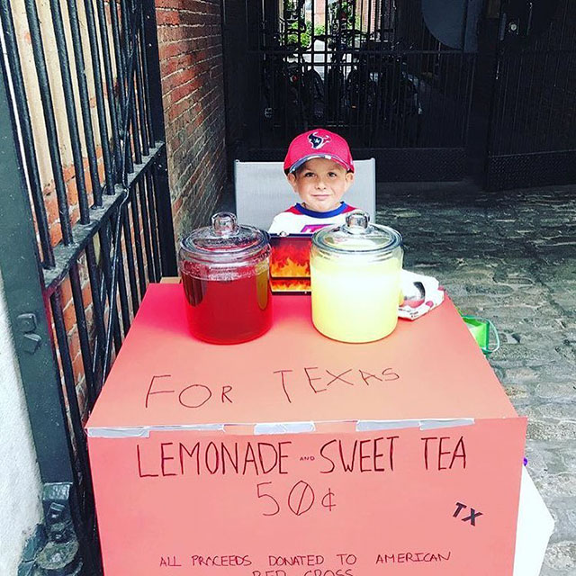 Kid selling lemonade to help raise money for the red cross.