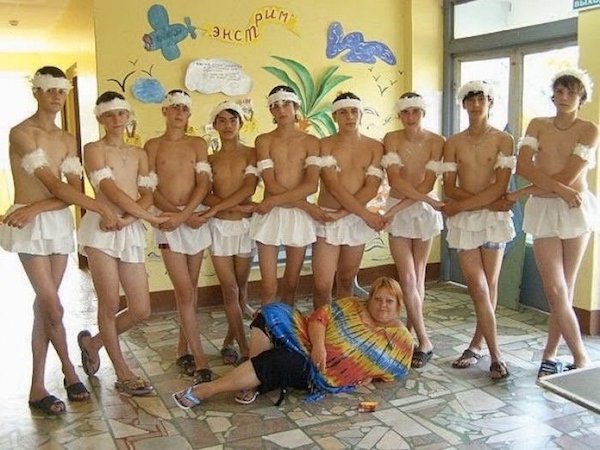 Woman dressed in festive moo-moo with a bunch of Russian boys dressed in tu-tu dresses.