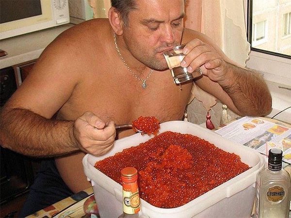 Russian man drinking vodka and eating caviar