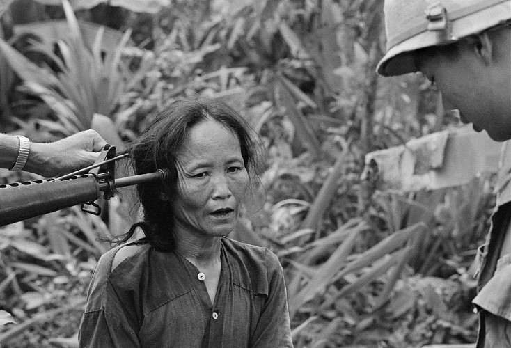 Two South Vietnamese soldiers question a suspected Viet Cong women at gunpoint in 1967