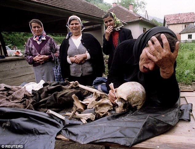 A Bosnian Serb woman mourns over the remains of her son killed in 1992 after it was found in a common grave, in Bosnia during the Balkan Wars
