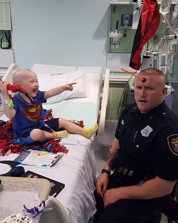Cop playing with kid who shoots him in forehead with suction arrow.