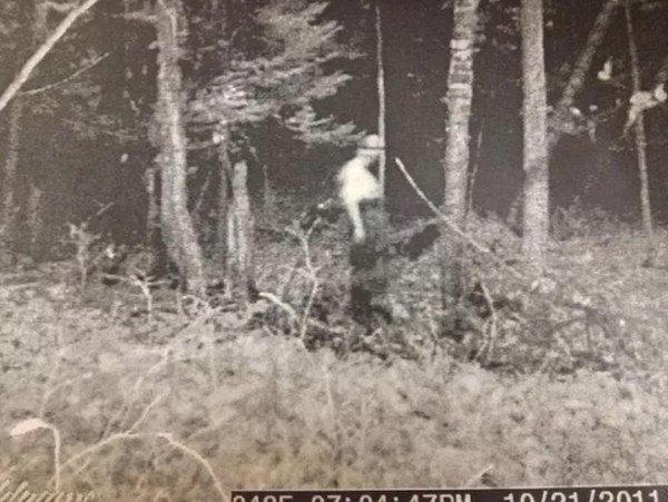“A friend of a friend was going through his photos from last year’s hunting season and found this pic. He says the trail cam is activated by movement yet there were no pics of the entity anywhere else except in this photo. If it were a person there would have been several photos where the person entered into the vision field of the camera, yet only this photo was taken.
The area in which this photo was taken is on private hunting property miles from any residential areas in Northern Michigan. Also at the end of October it is usually quite cold and pitch black dark out where this photo was taken.”
