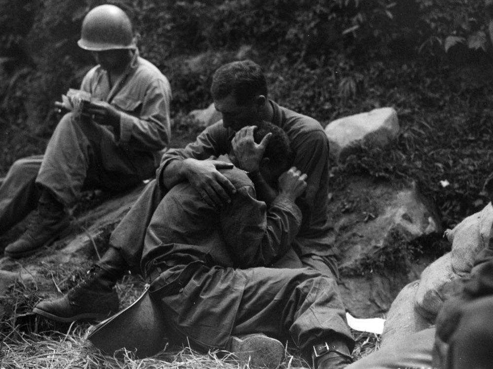 A grief stricken American infantryman is comforted by another soldier in the Haktong-ni area, Korea, August 28 1950.