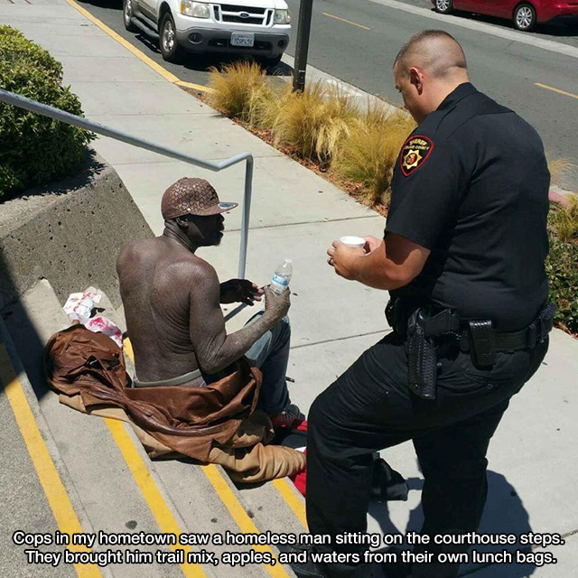 A police officer shares his lunch with a homeless man on the courthouse steps.