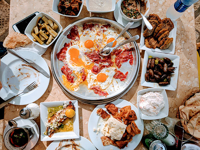 Egyptian breakfast: eggs with basterma, fava beans, falafel, sausages, brine cheese, herring, eggplant, tahina and lots of pickles