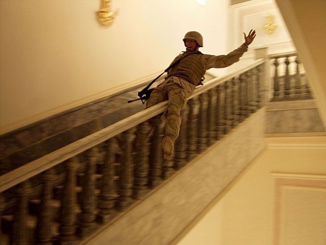 US soldier slides down the banister in one of Saddam Hussein’s palaces