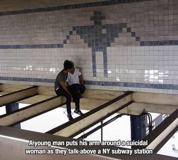 suicidal woman - A young man puts his arm around a suicidal woman as they talk above a Ny subway station