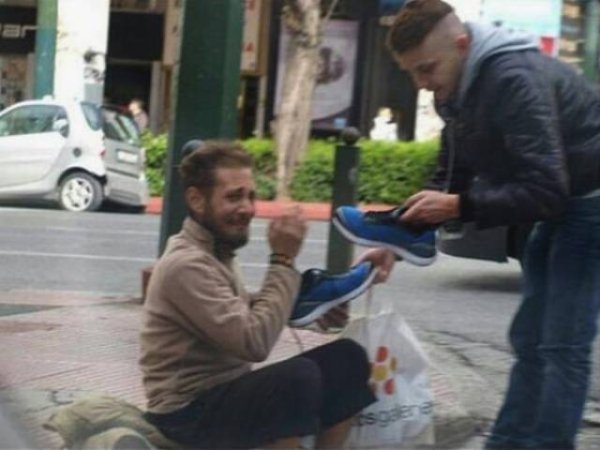 man gives homeless man shoes