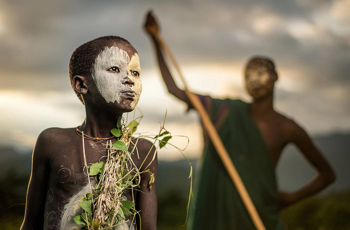 A boy of the nomadic Suri tribe of Ethiopia, in traditional face/body paint and attire