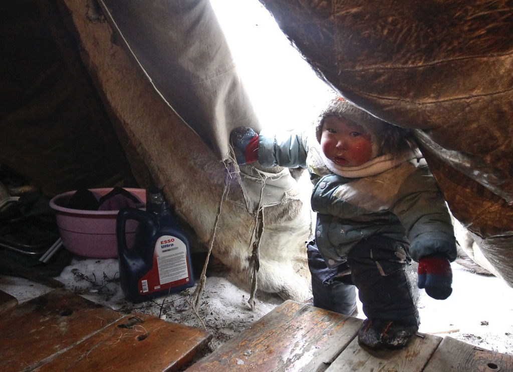 A Nenet boy seeks shelter in his tent away from the harsh Tundra, 50km north of Naryan-Mar, Russia