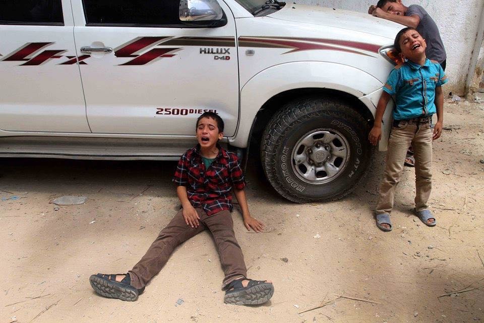 The only survivors of the Battsh family, mourning the death of their parents and siblings. Picture taken at Shujaiyya massacre – Gaza City – 7/20/2014