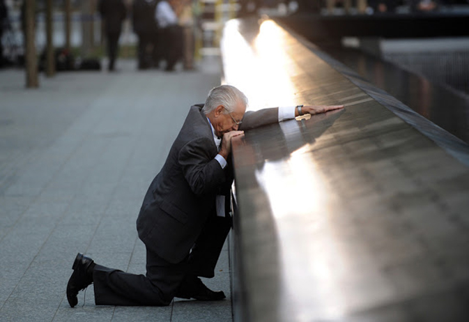 Robert Peraza kneels down in grief before his son’s name on the 9/11 Memorial