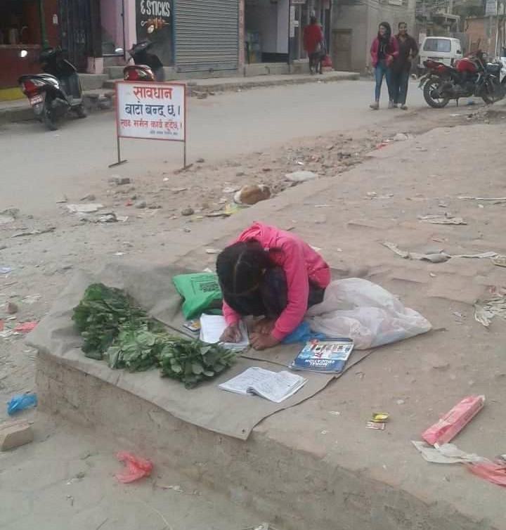 A little girl doing her homework and make a living in Nepal