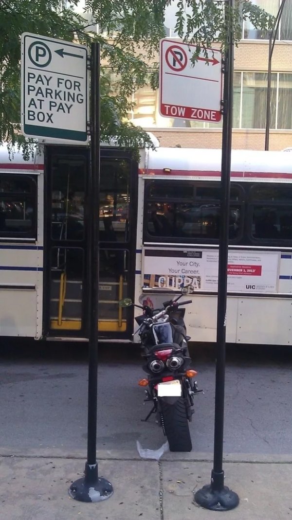 motorcycle parked between signs - Pay For Parking At Pay Tow Zone Box Your City. Your Career Uic