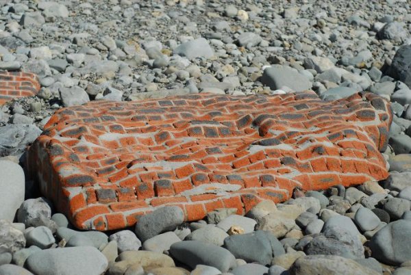 This brick wall was eroded by the sea.