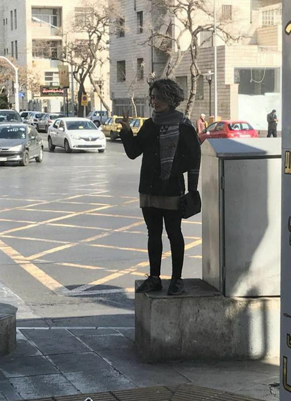 Iranian woman takes off her compulsory hijab and protests against mandatory dress code for women