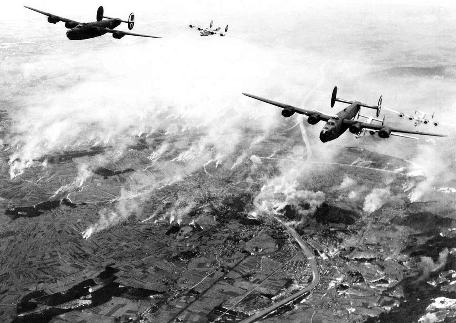 A formation of B-24s of Maj. General Nathan F. Twining’s U.S. Army 15th Air Force thunders over the railway yards of Salzburg, Austria, on December 27, 1944. The smoke created by their bombs mingles with that from the enemy’s many smudge pots.