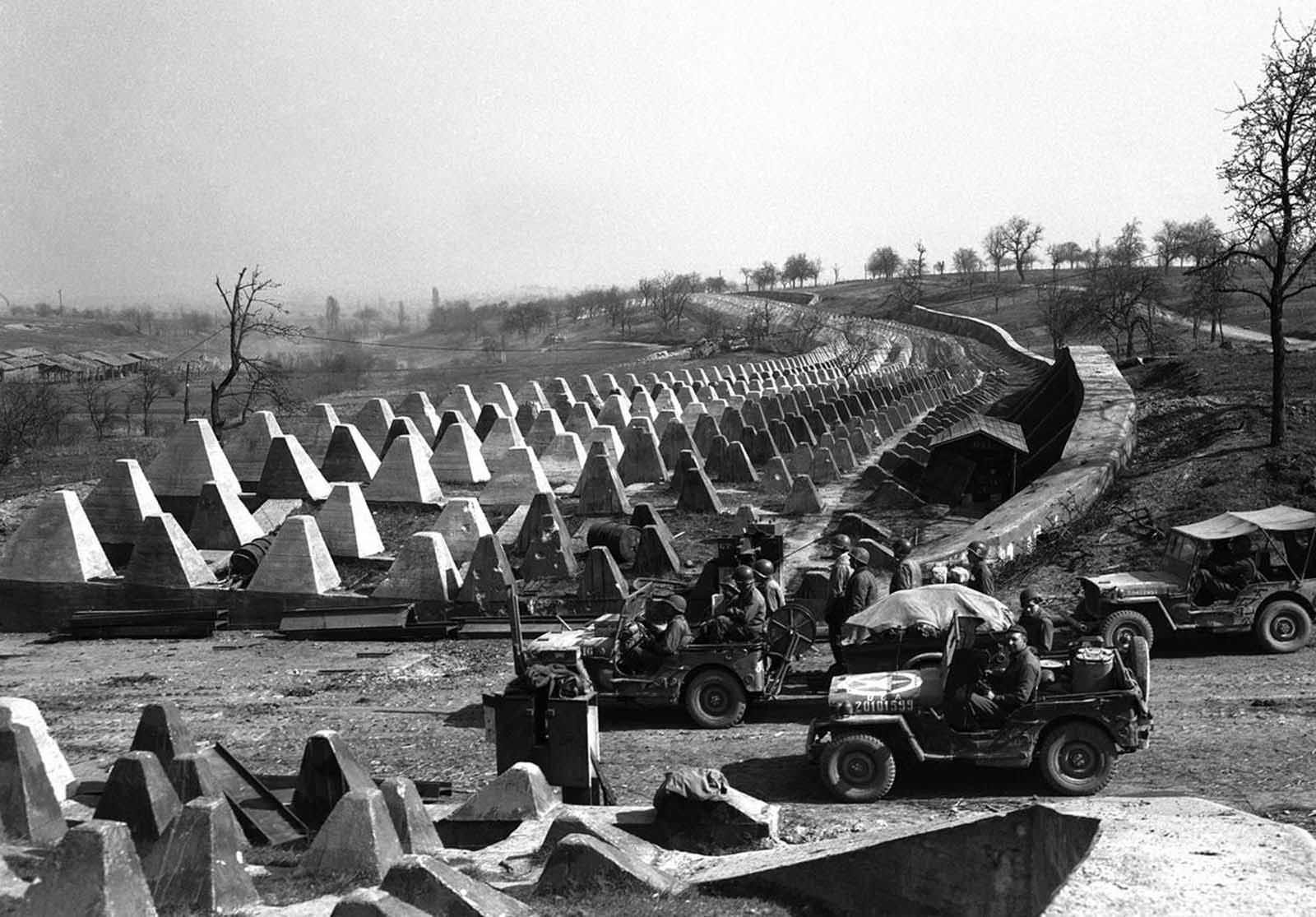 Men of the American 7th Army pour through a breach in the Siegfried Line defenses, on their way to Karlsruhe, Germany on March 27, 1945, which lies on the road to Stuttgart.
