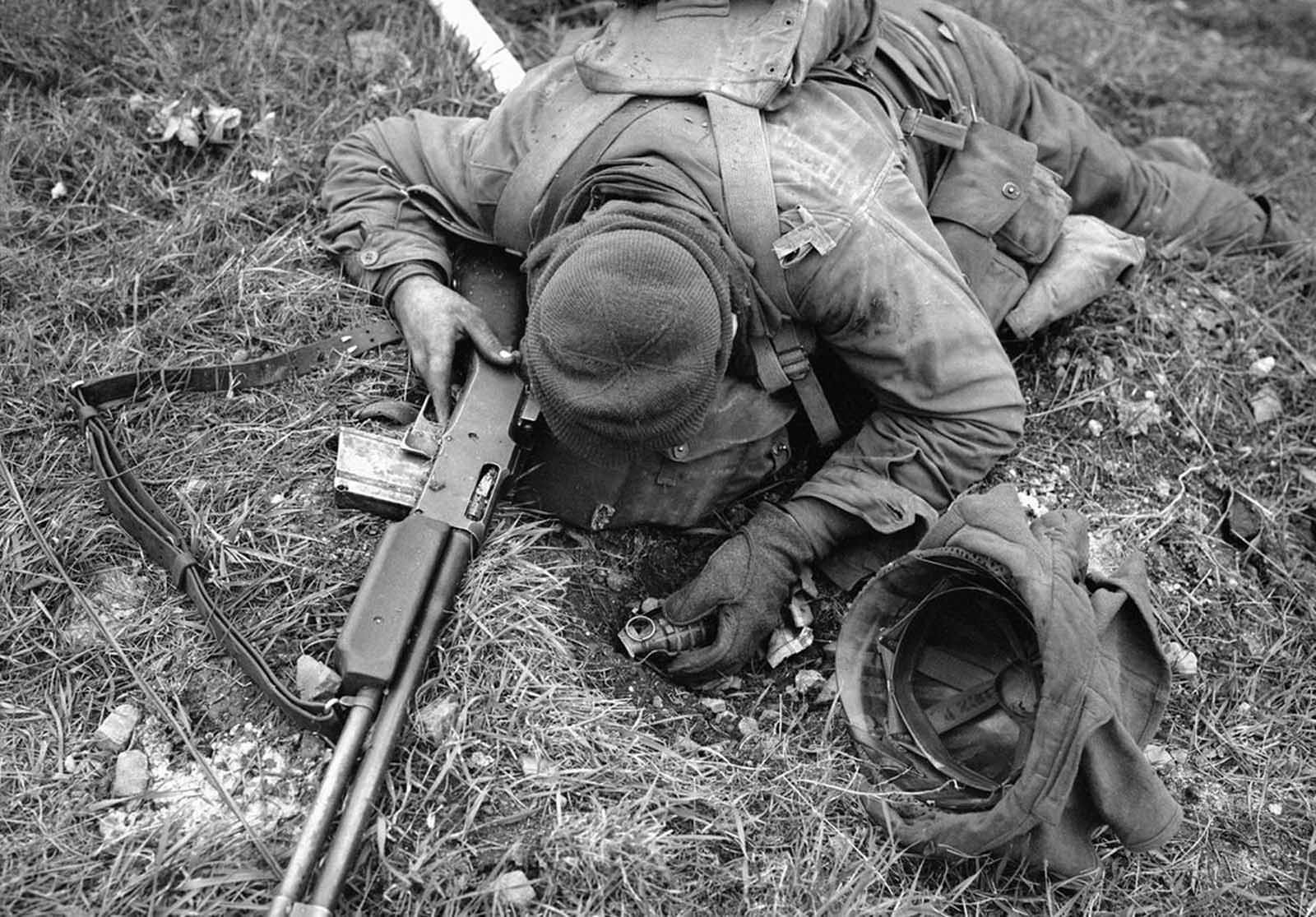 An unidentified American soldier, shot dead by a German sniper, clutches his rifle and hand grenade in March of 1945 in Coblenz, Germany.