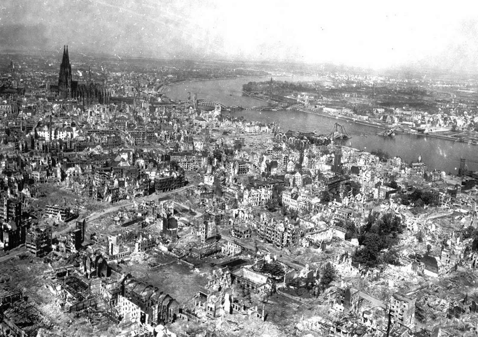 War-torn Cologne Cathedral stands out of the devastated area on the west bank of the Rhine, in Cologne, Germany, April 24, 1945. The railroad station and the Hohenzollern Bridge, at right, are completely destroyed after three years of Allied air raids.