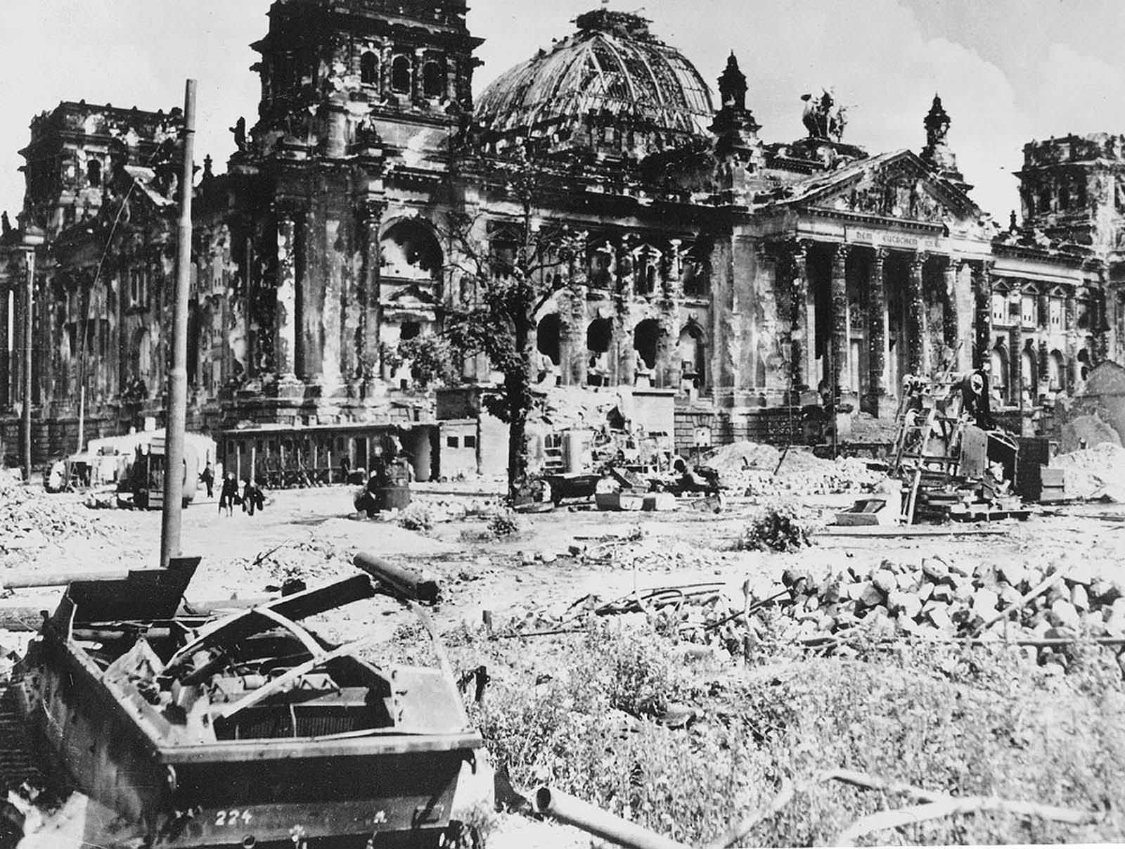 The wrecked Reichstag building in Berlin, Germany, with a destroyed German military vehicle in the foreground, at the end of World War II.