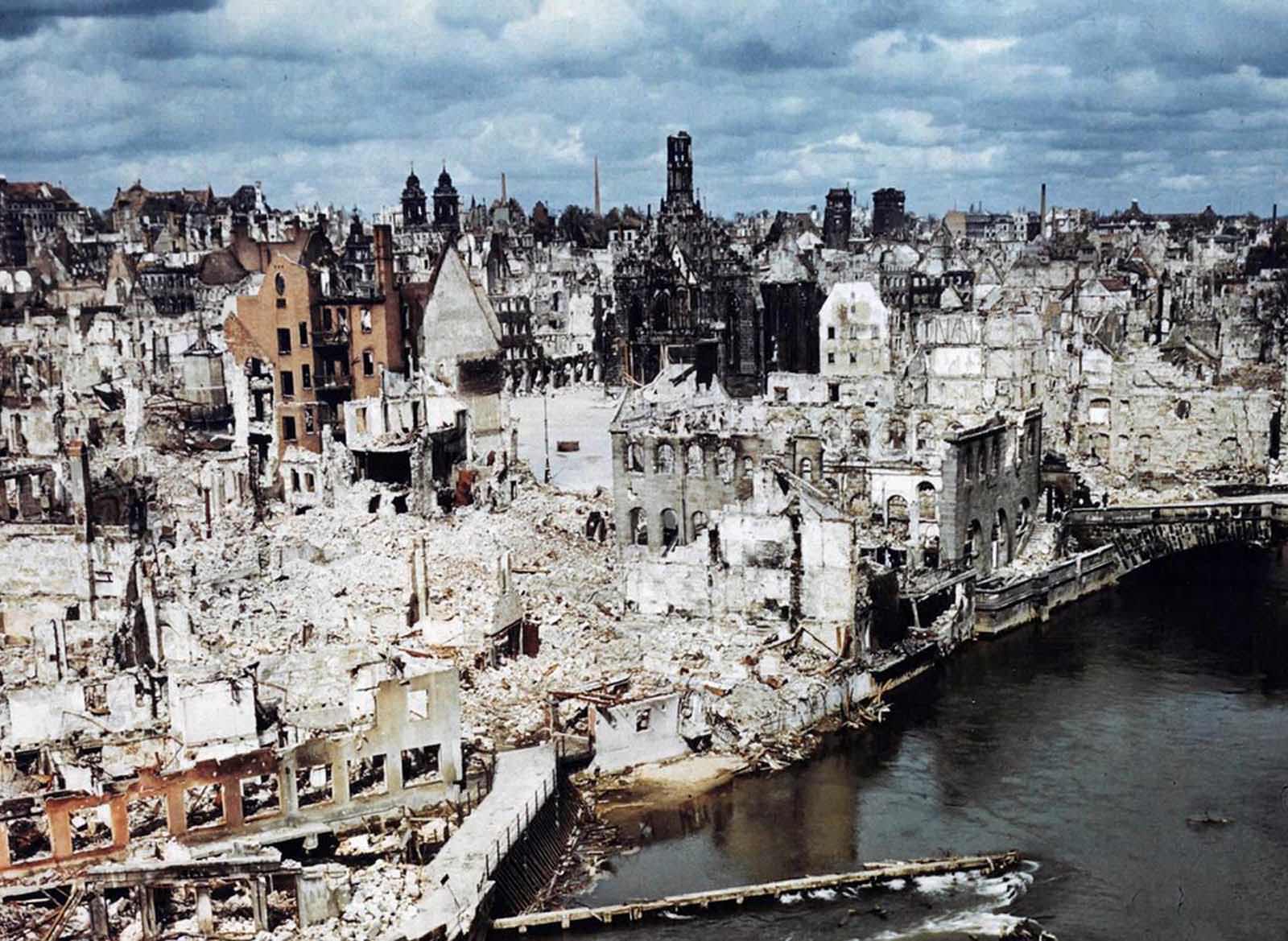 A color photograph of the bombed-out historic city of Nuremberg, Germany in June of 1945, after the end of World War II. Nuremberg had been the host of huge Nazi Party conventions from 1927 to 1938. The last scheduled rally in 1939 was canceled at the last minute due to a scheduling conflict: the German invasion of Poland one day prior to the rally date. The city was also the birthplace of the Nuremberg Laws, a set of draconian antisemitic laws adopted by Nazi Germany. Allied bombings from 1943 until 1945 destroyed more than 90% of the city center, and killed more than 6,000 residents. Nuremberg would soon become famous one last time as the host of the Nuremberg Trials — a series of military tribunals set up to prosecute the surviving leaders of Nazi Germany. The war crimes these men were charged with included “Crimes Against Humanity”, the systematic murder of more than 10 million people, including some 6 million Jews.