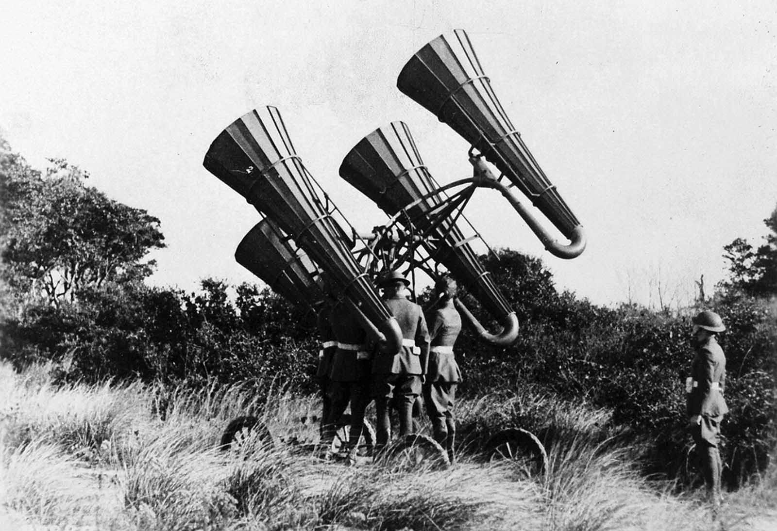 American troops using a newly-developed acoustic locator, mounted on a wheeled platform. The large horns amplified distant sounds, monitored through headphones worn by a crew member, who could direct the platform to move and pinpoint distant enemy aircraft. Development of passive acoustic location accelerated during World War I, later surpassed by the development of radar in the 1940s