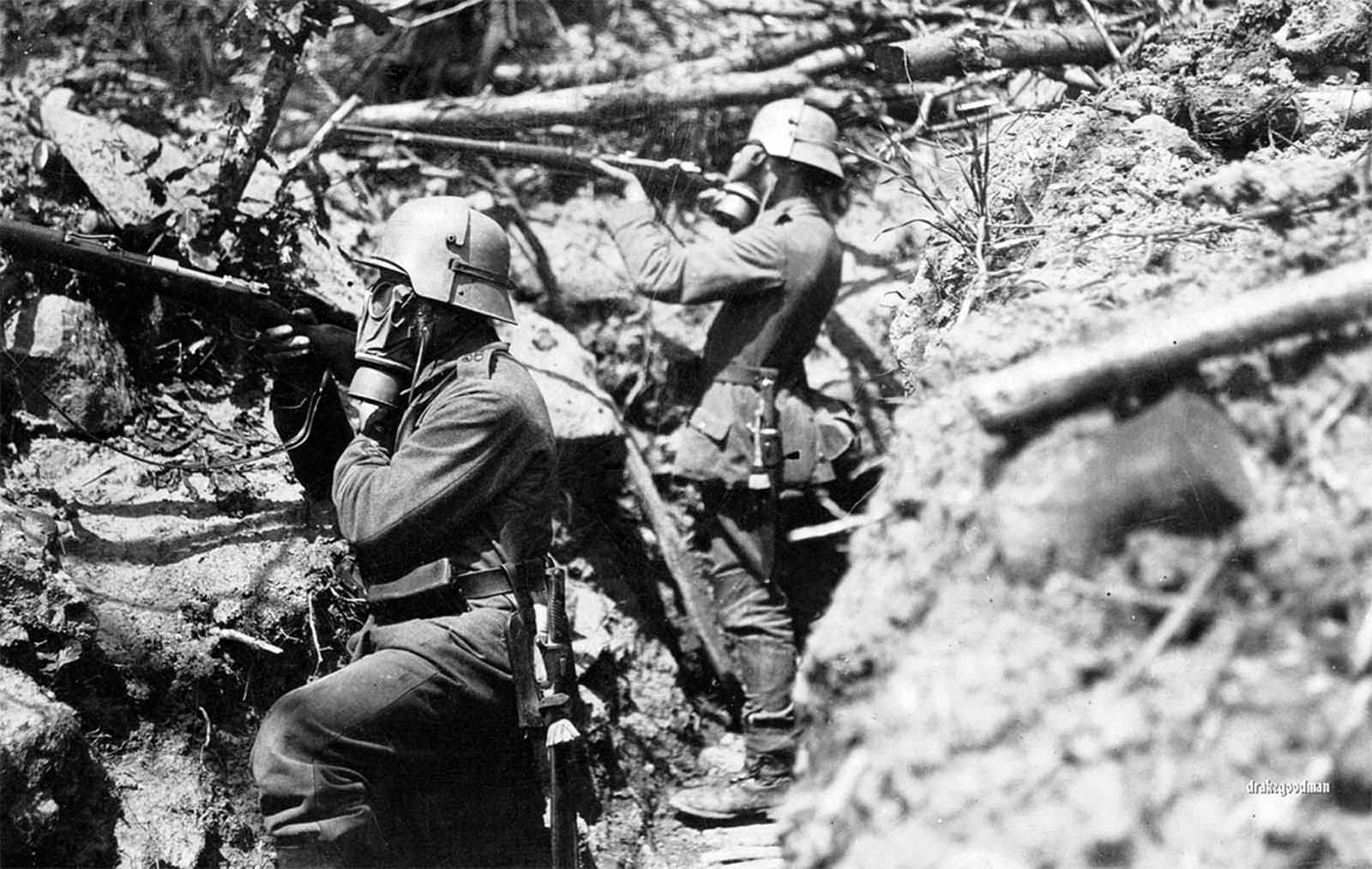German infantrymen from Infanterie-Regiment Vogel von Falkenstein Nr.56 adopt a fighting pose in a communication trench somewhere on the the Western Front. Both soldiers are wearing gas masks and Stahlhelm helmets, with brow plate attachments called stirnpanzers. The stirnpanzer was a heavy steel plate used for additional protection for snipers and raiding parties in the trenches, where popping your head above ground for a look could be lethal move