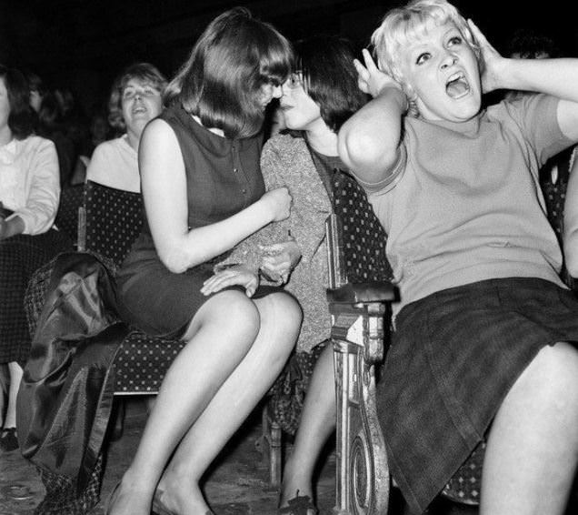 Two girls shаre а moment at a Beatles concert.