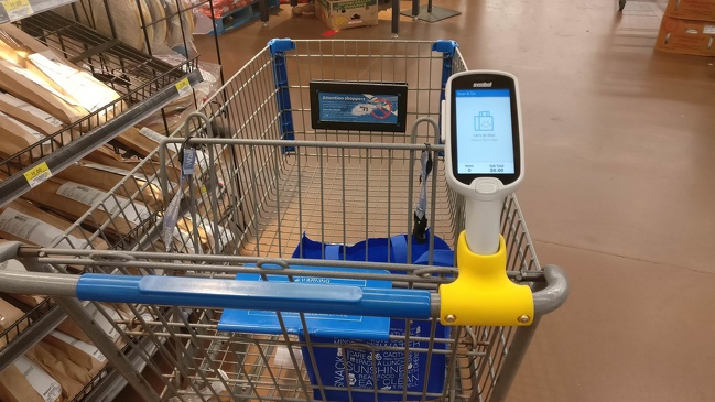 This shopping cart has a scanner that sums up the prices of products that are put inside it.