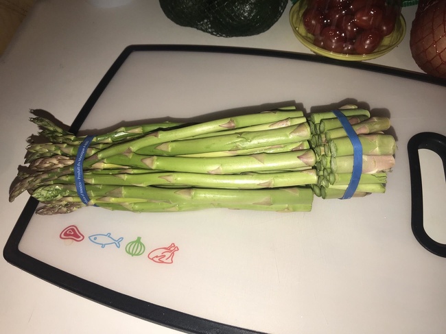 Keep the bands on the asparagus so they don’t roll around while you cut the ends off.