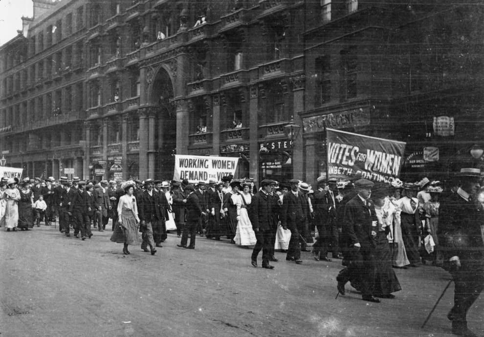 Men and women march in a womens suffrage parade in London, England in 1900.