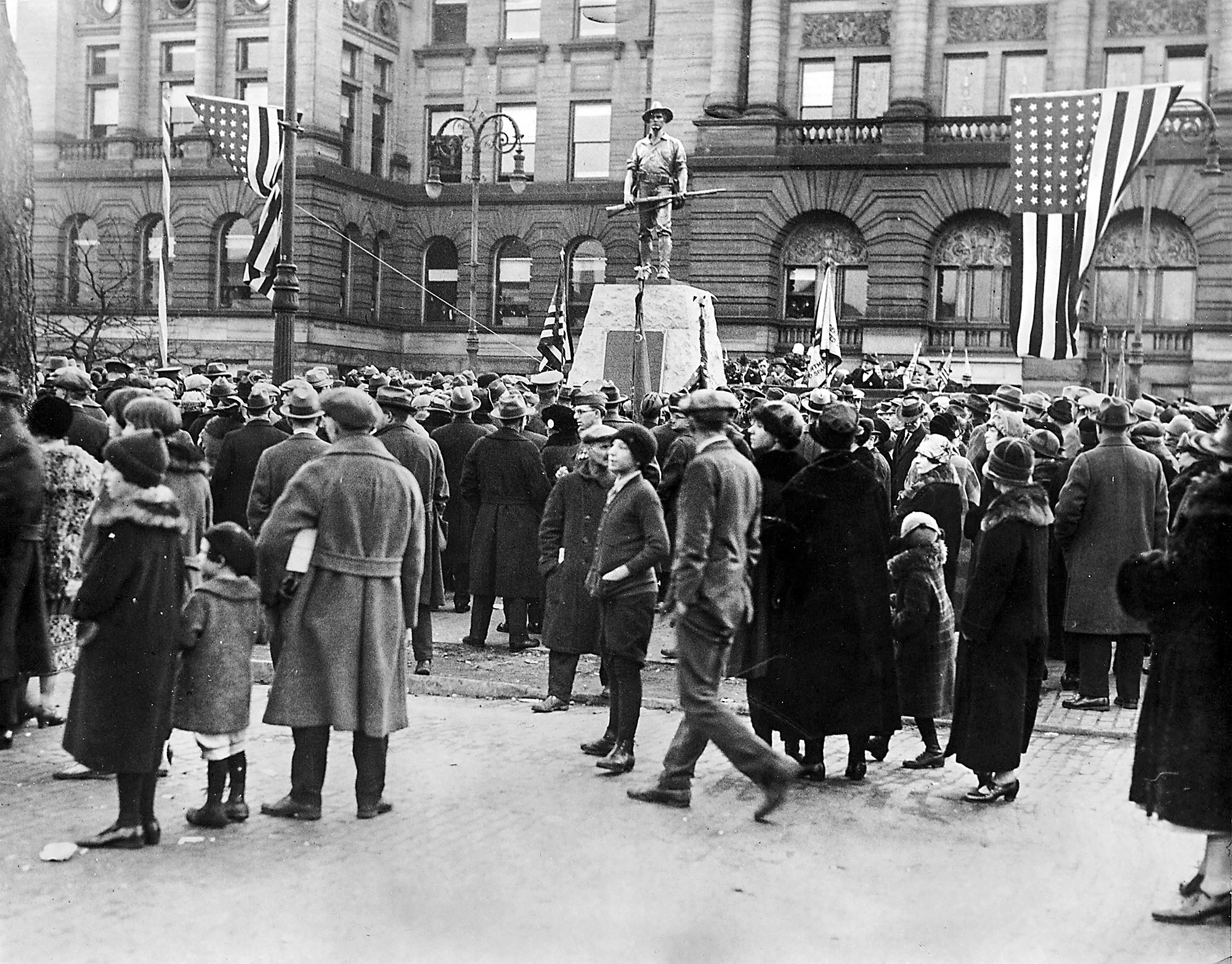 Veterans from the Civil War, Spanish American War, and WWI attend a ceremony with thousands of civilians to dedicate this memorial statue on the lawn of the Lucas County Courthouse in Ohio, US in 1927.