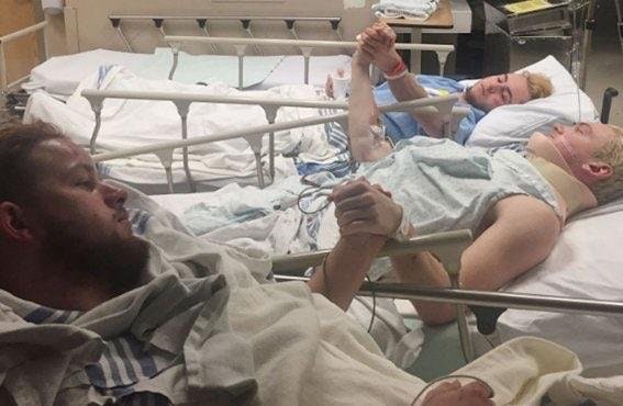 Three members of the Humboldt Broncos holding hands in the hospital after 15+ members of their hockey team died in bus accident