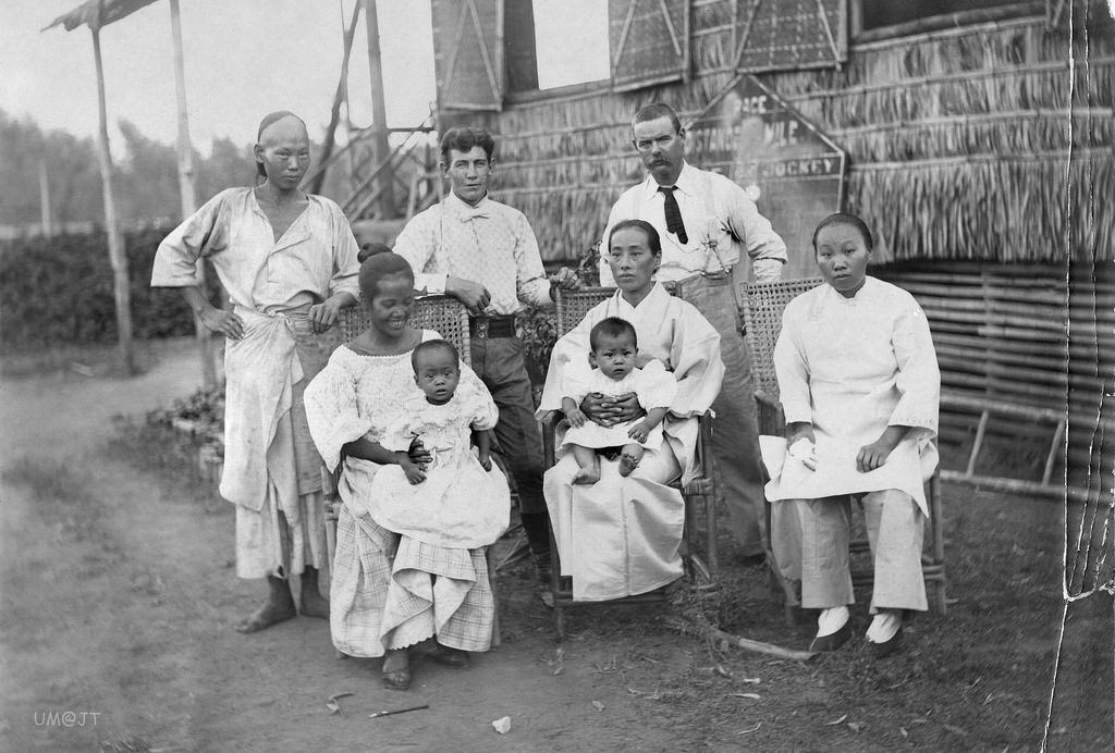 2 Americans pose with a Chinese man and woman (far left and far right), a Japanese woman and her baby (center) and a Filipino woman and her baby in the Philippines in 1902.