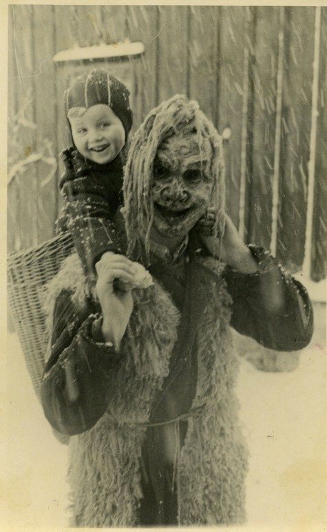 A boy rides a man dressed as a demon for the Krampus Parade in Austria in 1954.